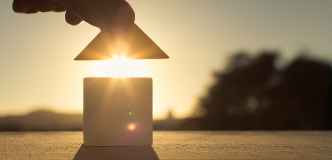 une main soulevant le toit d'une maison faisant apparaitre les rayons du soleil symbole de la confiance accordée aux murs à paris